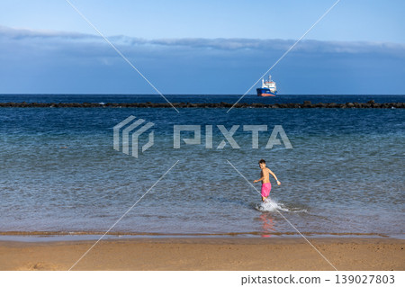 Active Boy Running In Sea Water Near Sandy Beach On Sunny Summer Day Active Boy Running In Sea Water Near Sandy Beach On Sunny Summer Day 139027803