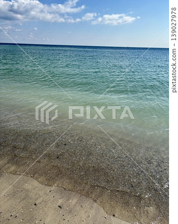 Beautiful turquoise sea water with small waves on a sandy beach Beautiful turquoise sea water with small waves on a sandy beach 139027978