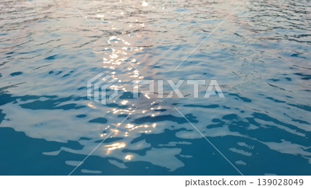 Sunlight Reflection on Calm Blue Water Surface Creating Sparkling Natural Background 139028049