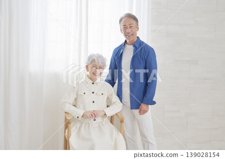 一對老年夫婦在客廳看著鏡頭，這是他們的肖像照。 139028154