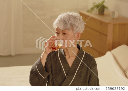 老年婦女在臥室喝威士忌 139028192