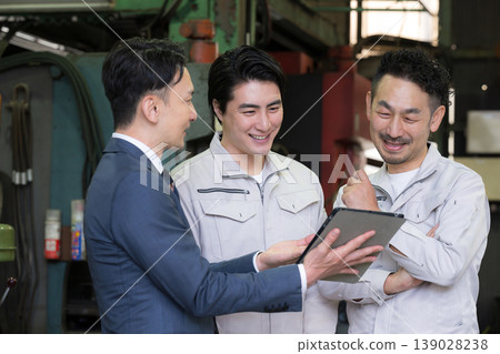 一名工廠工人和一名商人使用平板電腦開會;引入了數位轉型、資訊科技和人工智慧驅動的機械。 一名工廠工人和一名商人使用平板電腦開會;引入了數位轉型、資訊科技和人工智慧驅動的機械。 139028238