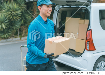A smiling delivery person heading out to deliver a package. A smiling delivery person heading out to deliver a package. 139028443