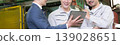 一名工廠工人和一名商人使用平板電腦開會；引入了數位轉型、資訊科技和人工智慧驅動的機械。 139028651