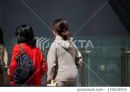 春天,女遊客們漫步在熙熙攘攘的城市街道上。 春天,女遊客們漫步在熙熙攘攘的城市街道上。 139028934