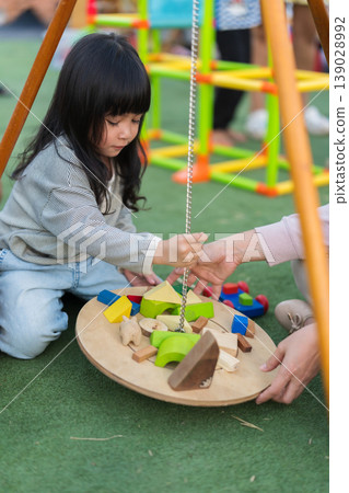 mother and preschool child girl playing with wooden toy block at outdoor mother and preschool child girl playing with wooden toy block at outdoor 139028992