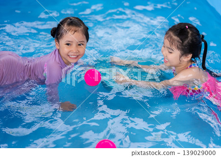 happy preschool child girl playing together with her sister in outdoor portable swimming pool in backyard 139029000