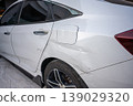 White car side with visible rear door damage and scratches on body panel 139029320