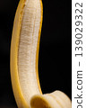 Close-up of Partially Peeled Banana on Black Background 139029322