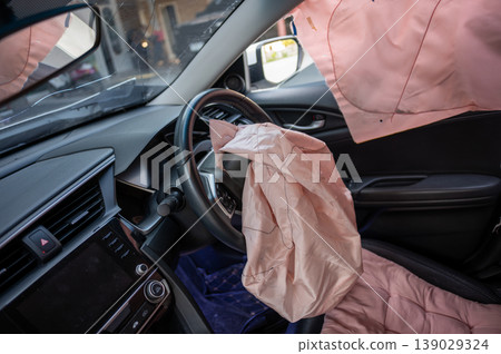 Deployed Airbags Inside Car Interior After Accident showing Steering Wheel and Dashboard 139029324