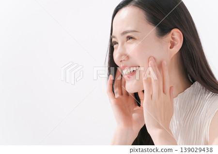 A woman smiling with her hand on her cheek. 139029438