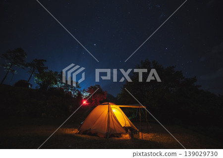 nature traveling with orange camping tent on mountain with milky way and star background nature traveling with orange camping tent on mountain with milky way and star background 139029730