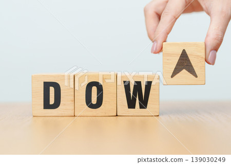 Hand change wooden block of Dow Jones Index text to UP and Down arrow symbol icon. stock market index, trade, trade company in the United States, financial growth and Cut loss concept Hand change wooden block of Dow Jones Index text to UP and Down arrow symbol icon. stock market index, trade, trade company in the United States, financial growth and Cut loss concept 139030249