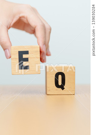 hand change wooden block from IQ to EQ, balance between intelligence quotient and emotional quotient, AQ Adversity, MQ, Moral, SQ and Social quotient concepts 139030284