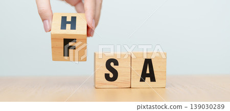 hand change wooden block from FSA to HSA. Flexible Spending Account and Health Savings Account, Medical Expenses, Tax Benefits and healthcare concepts 139030289