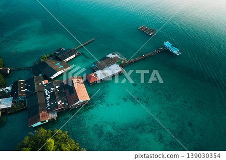 Aerial view of a traditional coastal village living in harmony with nature, showcasing sustainable living and slow life. Aerial view of a traditional coastal village living in harmony with nature, showcasing sustainable living and slow life. 139030354