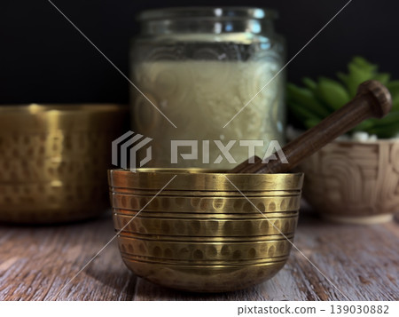 Brass Singing Bowl with Wooden Mallet on Rustic Table Symbolizing Meditation Sound Healing Mindfulness and Relaxation with Warm Lighting and Natural Wellness Spa Background Brass Singing Bowl with Wooden Mallet on Rustic Table Symbolizing Meditation Sound Healing Mindfulness and Relaxation with Warm Lighting and Natural Wellness Spa Background 139030882