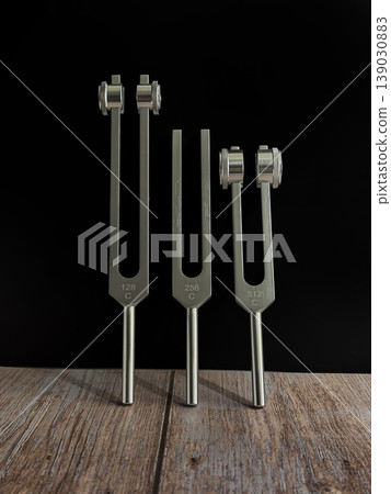 Set of Metal Tuning Forks for Sound Healing Therapy on Wooden Surface with Dark Background Representing Vibration Frequency Meditation Wellness Holistic Therapy and Alternative Healing Concept Set of Metal Tuning Forks for Sound Healing Therapy on Wooden Surface with Dark Background Representing Vibration Frequency Meditation Wellness Holistic Therapy and Alternative Healing Concept 139030883