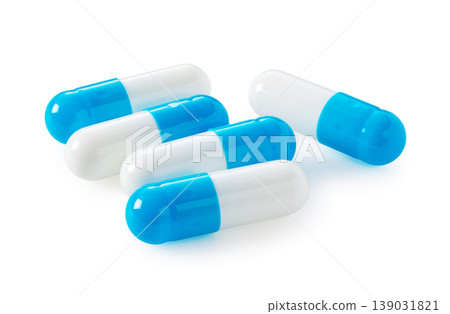 一堆藍白相間的膠囊，背景為白色。圖片素材可用於醫療或保健品用途。 139031821
