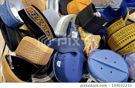 Yogyakarta, Indonesia - March 18th 2026: traditional Kufi caps and Muslim prayer hats, showcasing various colors, intricate patterns, and textures. Yogyakarta, Indonesia - March 18th 2026: traditional Kufi caps and Muslim prayer hats, showcasing various colors, intricate patterns, and textures. 139032232