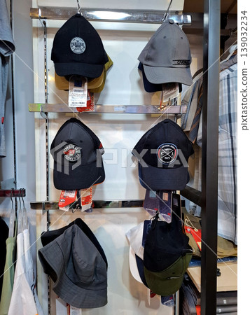 Yogyakarta, Indonesia - March 18th 2026: Collection of stylish baseball caps and bucket hats displayed neatly on metal racks in a modern retail clothing store. Perfect for fashion, 139032234