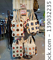 Yogyakarta, Indonesia - March 18th 2026: Colorful handmade crochet bags featuring intricate floral patterns displayed on a retail rack in a bustling store 139032235