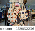 Yogyakarta, Indonesia - March 18th 2026: handcrafted knitted tote bags adorned with distinct floral and geometric motifs, showcased within a bustling department store environment. 139032236