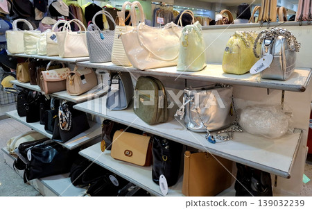 Yogyakarta, Indonesia - March 18th 2026: Multiple shelves stocked with a wide variety of stylish handbags and purses in a retail store setting Yogyakarta, Indonesia - March 18th 2026: Multiple shelves stocked with a wide variety of stylish handbags and purses in a retail store setting 139032239