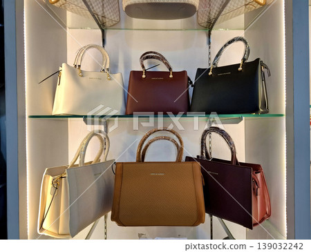 Yogyakarta, Indonesia - March 18th 2026: Six elegant women's handbags in various colors are meticulously displayed on clear glass shelves within a brightly lit retail store Yogyakarta, Indonesia - March 18th 2026: Six elegant women's handbags in various colors are meticulously displayed on clear glass shelves within a brightly lit retail store 139032242