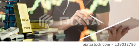 Double exposure of a female investor using a digital tablet with gold bullion bars, cash money, and stock market trading charts. Online wealth management concept. 139032786
