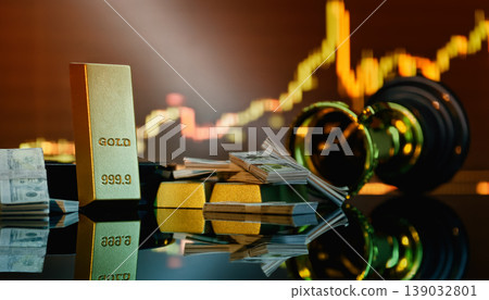 Gold investment and financial success concept: 999.9 gold bars, dollar cash, and a trophy against a blurred stock market chart. Gold investment and financial success concept: 999.9 gold bars, dollar cash, and a trophy against a blurred stock market chart. 139032801