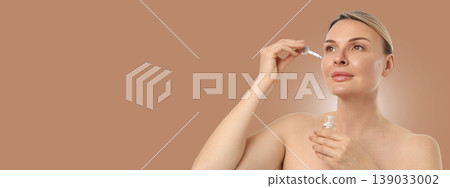 Woman carefully using serum on her face in a calm setting Woman carefully using serum on her face in a calm setting 139033002