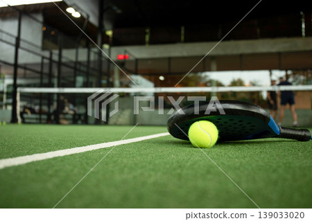 Padel game in a tropical setting with players on a green court Padel game in a tropical setting with players on a green court 139033020