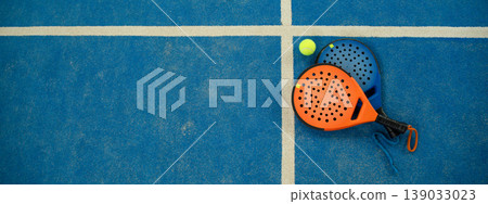 Padel gear waits on a blue court during a sunny day 139033023