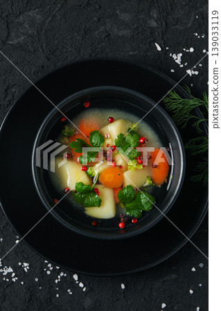 A bowl of soup contains carrots, potatoes, and herbs A bowl of soup contains carrots, potatoes, and herbs 139033119
