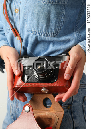 A person is holding a camera with a brown leather case in hands A person is holding a camera with a brown leather case in hands 139033266