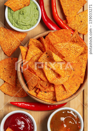 Chips served with different dips and fresh peppers on a table Chips served with different dips and fresh peppers on a table 139033271