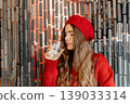 Woman Beret Water drinking from a glass in a cafe while wearing a red sweater for healthy hydration 139033314