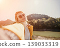 Woman Selfie Mountains Landscape - Smiling woman takes a selfie in front of a mountain range. 139033319