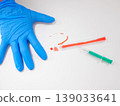 Single Blue Nitrile Glove Laid Flat Near Syringe And Spill, PPE Readiness And Inspection Scene For Safety 139033641