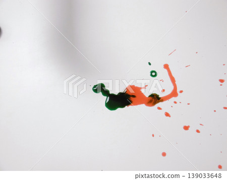 Green And Red Paints Blending Into Organic Shape Across White Background, Viscous Droplets And Delicate Trails 139033648