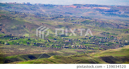 Breathtaking view of rolling green hills with small village nestled in valley Breathtaking view of rolling green hills with small village nestled in valley 139034520