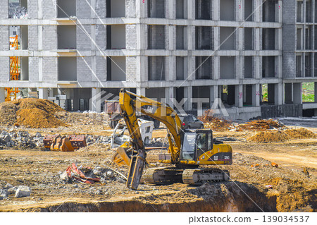 Excavator operates near unfinished concrete structure Excavator operates near unfinished concrete structure 139034537