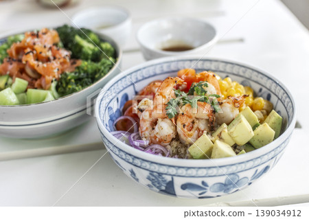 shrimp with avocado and mixed vegetables poke salad bowl on white table in outdoor cafe shrimp with avocado and mixed vegetables poke salad bowl on white table in outdoor cafe 139034912