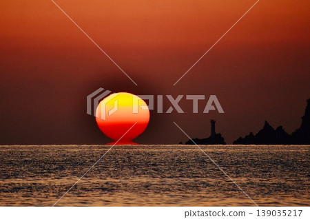 秋日的夕陽,像達摩不倒翁一樣,緩緩沉入燈塔旁。 秋日的夕陽,像達摩不倒翁一樣,緩緩沉入燈塔旁。 139035217