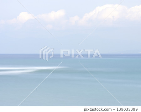 A calm sea in early summer, with a blue gradient background captured using a slow shutter speed. 139035399