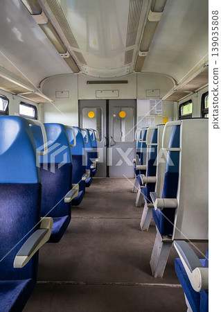 Empty passenger train carriage with rows of blue seats. 139035808