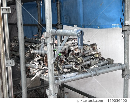 A scene of a construction site in the city and a stockpile of scaffolding materials. 139036400