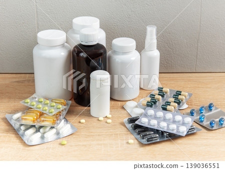 Medicine bottles and blister packs with various pills on wood Medicine bottles and blister packs with various pills on wood 139036551
