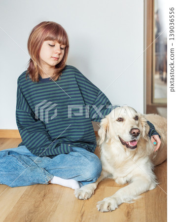 Young woman bonding with golden retriever dog at home Young woman bonding with golden retriever dog at home 139036556